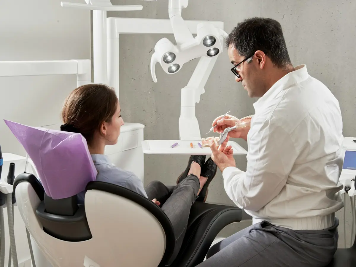 A dentist talking with a patient in the dental chair